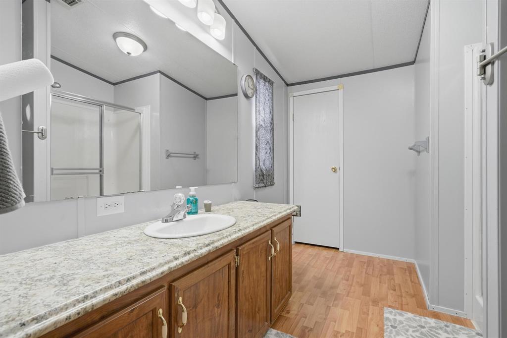 20082 County Road 304 Abilene, TX 79601 - Photo 15 of 36 a bathroom with a granite countertop sink a mirror and shower