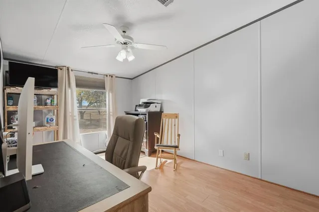 a view of a workspace with furniture and a window