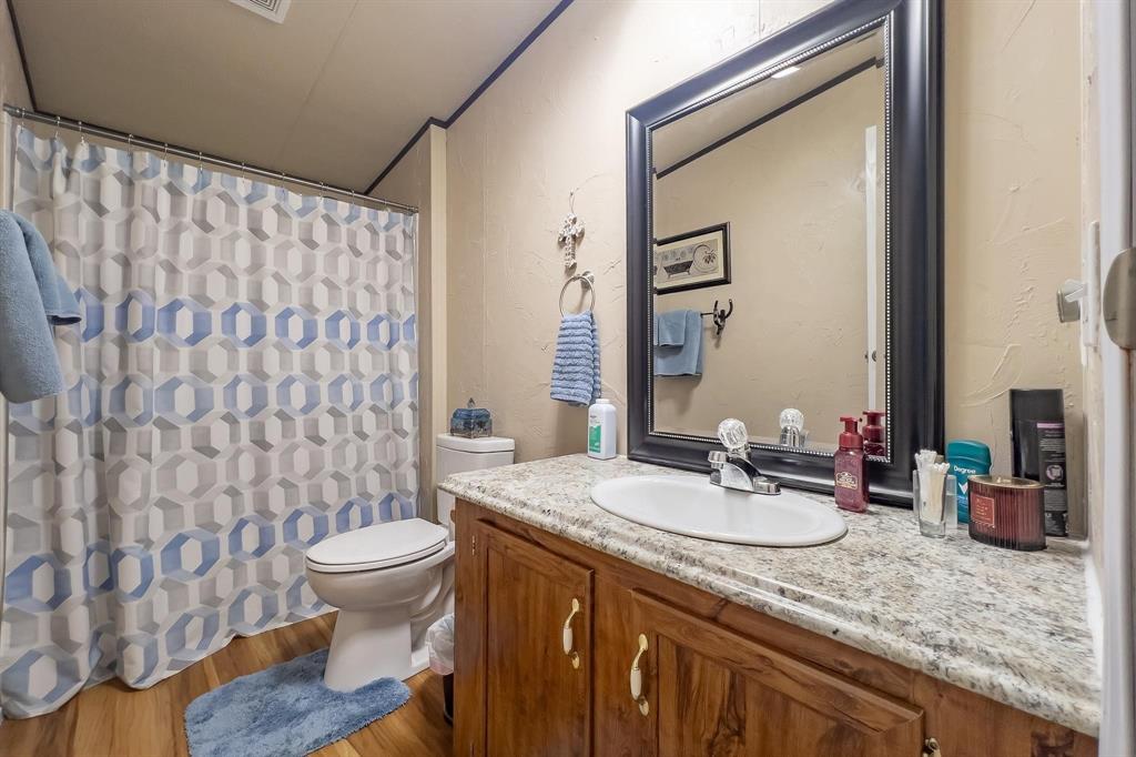 20082 County Road 304 Abilene, TX 79601 - Photo 21 of 36 a bathroom with a granite countertop sink toilet and a mirror