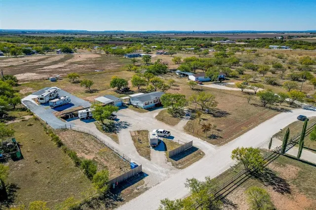 a front view of house with yard and trees in the background