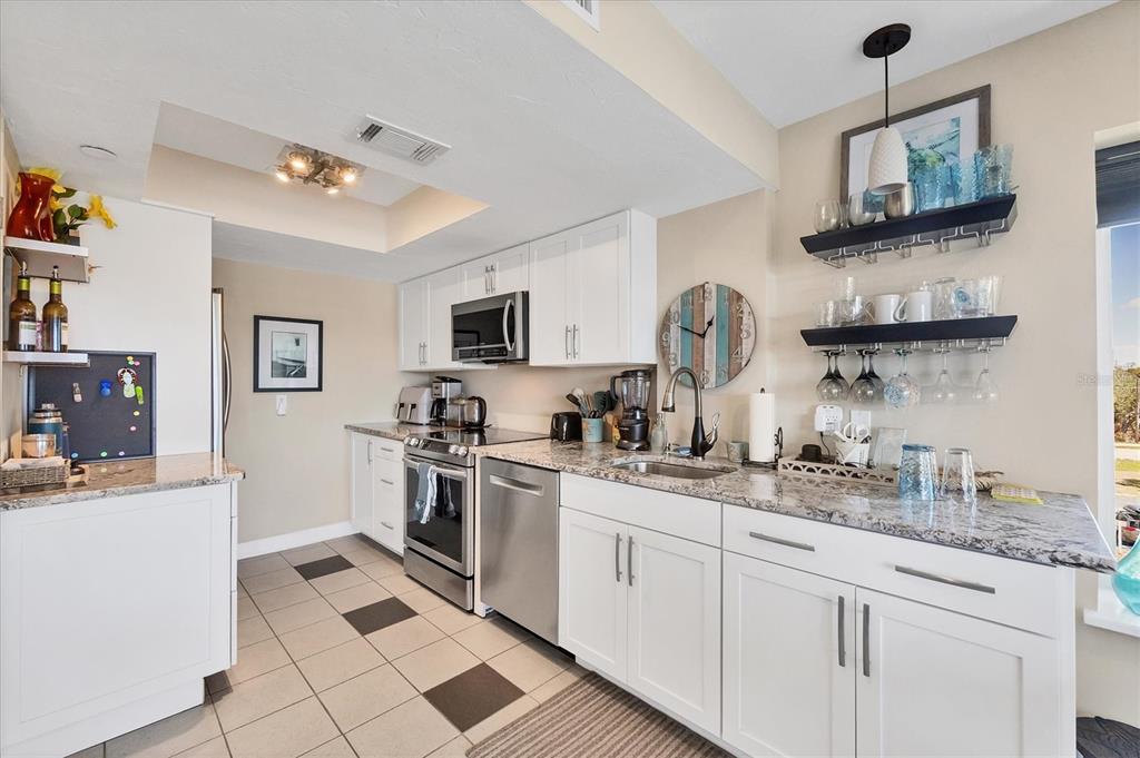 7070 Placida Road, Unit 1230 Placida, FL 33946 - Photo 19 of 60 a kitchen with stainless steel appliances granite countertop a sink and a stove top oven