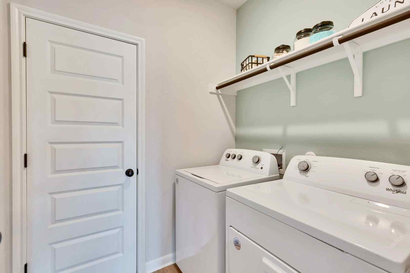 1205 Lavender Way Georgetown, TX 78628 - Photo 7 of 14 Functional utility space with convenient upper shelving and wood flooring.