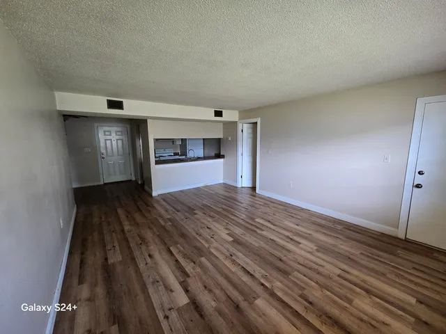 a view of empty room with wooden floor