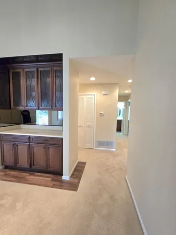 a view of an empty room with cabinet and a window