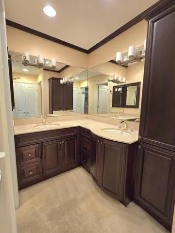 a bathroom with a granite countertop double vanity sink and mirror