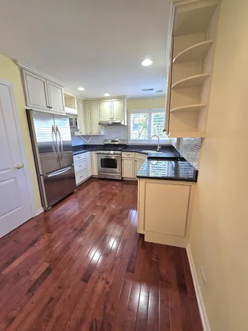 a kitchen with stainless steel appliances granite countertop a stove and a refrigerator