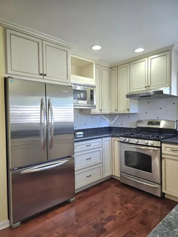 a kitchen with granite countertop stainless steel appliances and wooden cabinets