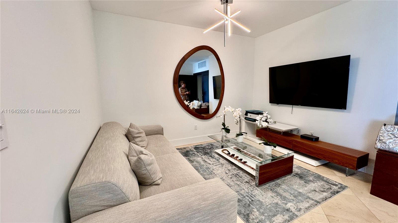 1331 Brickell Bay Drive, Unit 1109 Miami, FL 33131 - Photo 13 of 30 a living room with furniture and a flat screen tv
