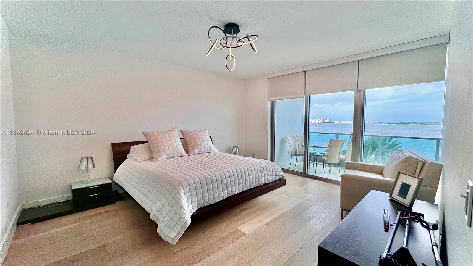 1331 Brickell Bay Drive, Unit 1109 Miami, FL 33131 - Photo 16 of 30 a bedroom with a bed and a chandelier
