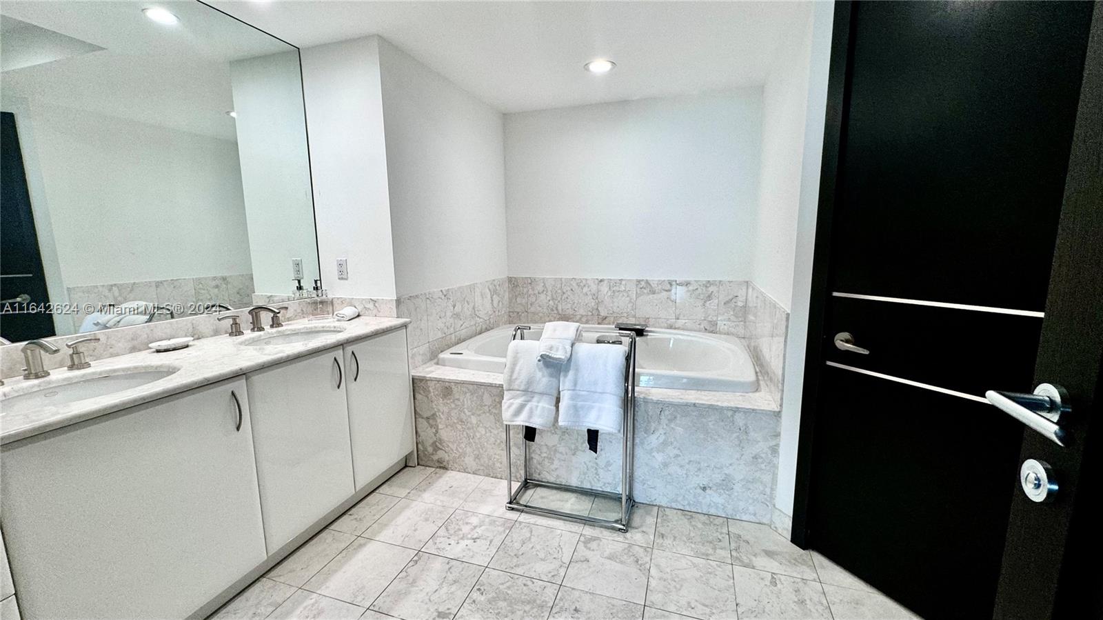 1331 Brickell Bay Drive, Unit 1109 Miami, FL 33131 - Photo 18 of 30 a bathroom with a sink vanity and a mirror