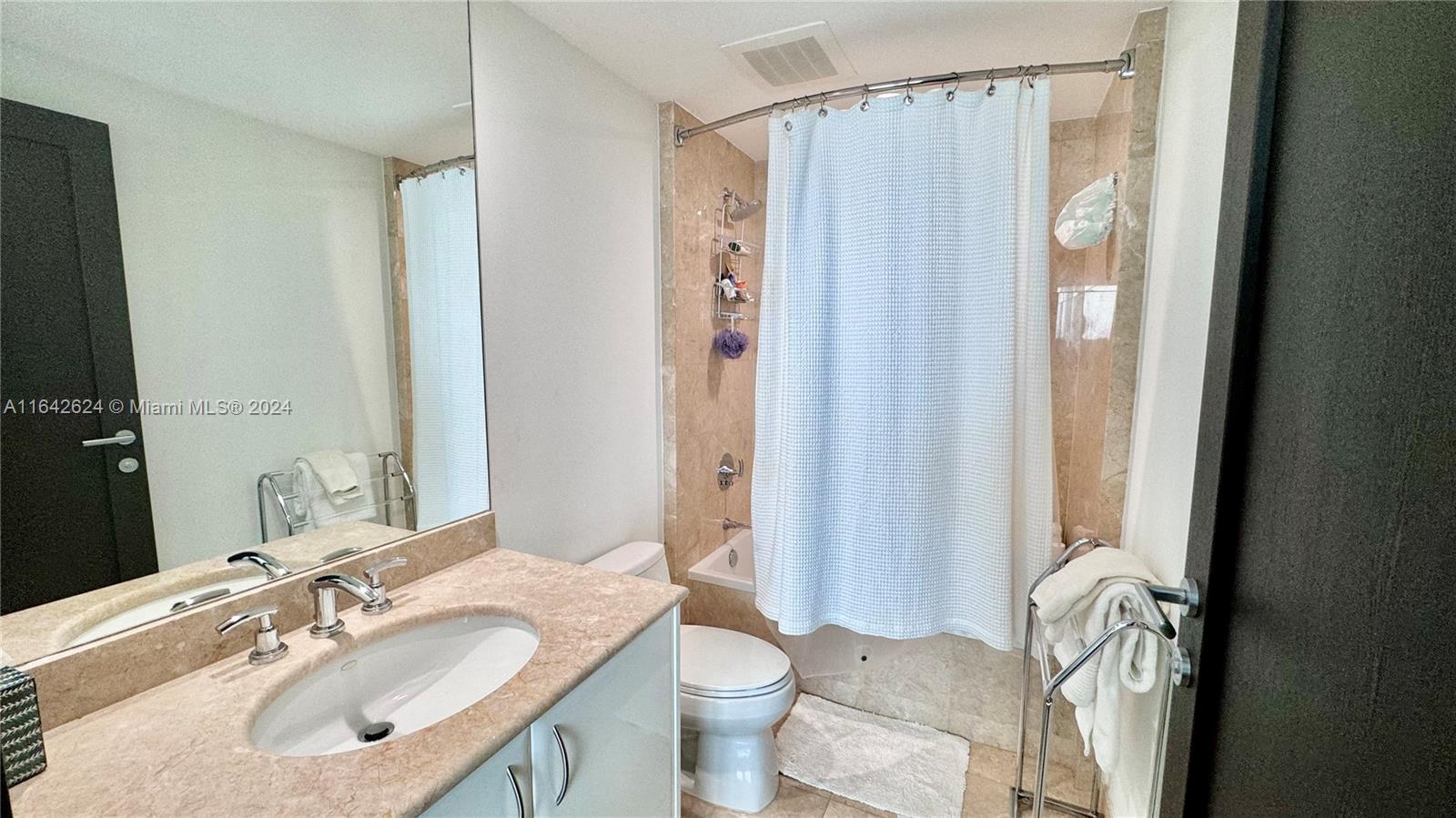 1331 Brickell Bay Drive, Unit 1109 Miami, FL 33131 - Photo 24 of 30 a bathroom with a sink a toilet and shower curtain