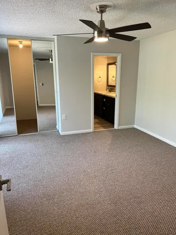 an empty room with a bathroom and a mirror