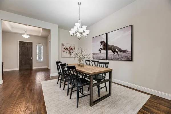 a view of a dining room with furniture wooden floor and a chandelier