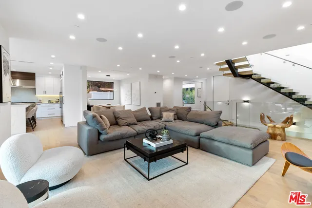 a kitchen that has a lot of white cabinets and stainless steel appliances
