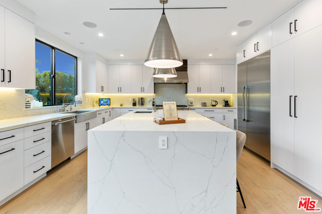 731 North Curson Avenue Los Angeles, CA 90046 - Photo 22 of 75 a kitchen that has a lot of white cabinets and stainless steel appliances