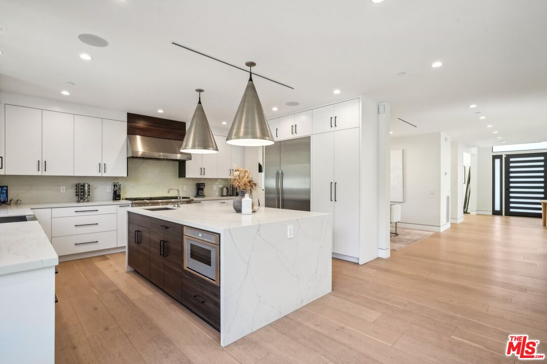 731 North Curson Avenue Los Angeles, CA 90046 - Photo 23 of 75 a kitchen with stainless steel appliances granite countertop a stove a sink and a refrigerator
