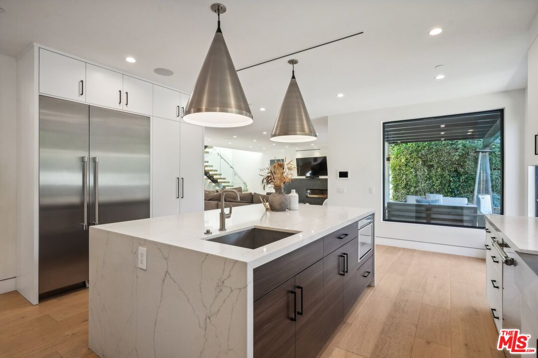 731 North Curson Avenue Los Angeles, CA 90046 - Photo 24 of 75 a kitchen with stainless steel appliances a sink a stove a refrigerator and island