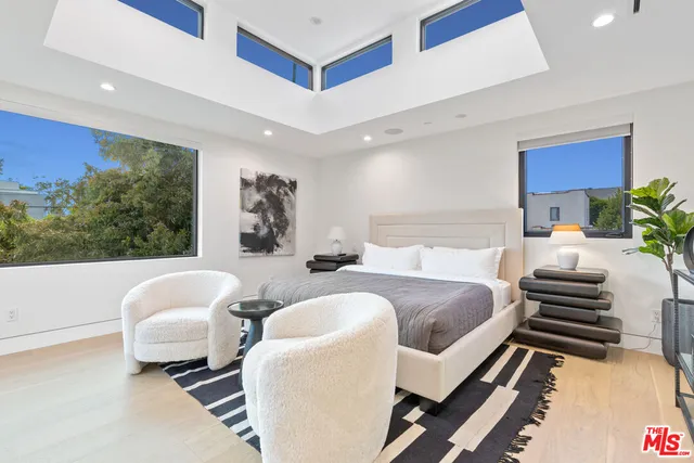 a living room with a bed and a large window