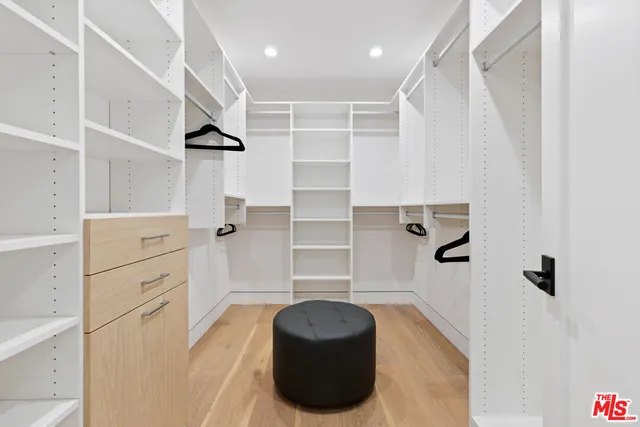 a bedroom with a large bed and wooden floor