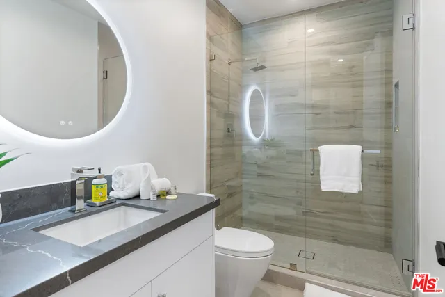 a bathroom with a sink a mirror and a potted plant