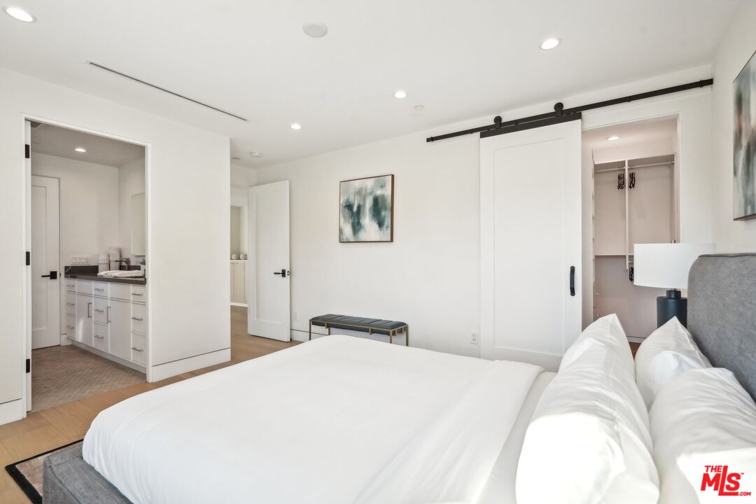 731 North Curson Avenue Los Angeles, CA 90046 - Photo 50 of 75 a bedroom with a large bed and wooden floor