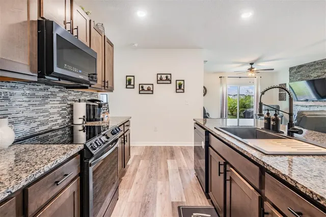 a kitchen with stainless steel appliances granite countertop a sink stove and microwave