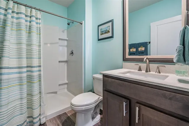 a bathroom with a granite countertop sink toilet and shower