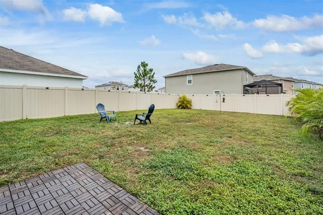 a backyard of a house with table and chairs