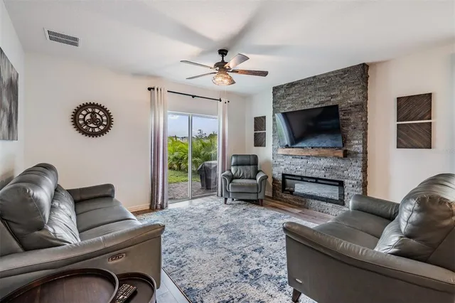 a living room with furniture a fireplace and a flat screen tv