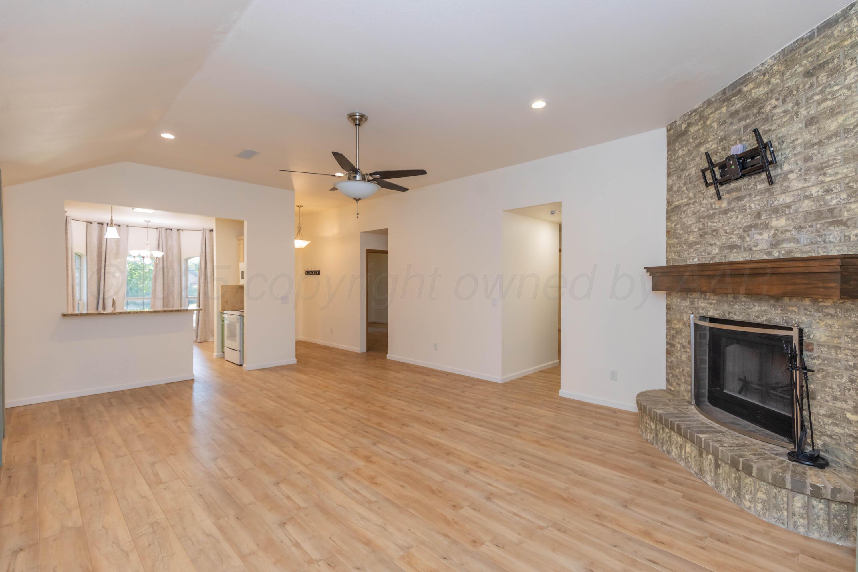 4810 Nimbus Lane Amarillo, TX 79110 - Photo 15 of 45 a view of an empty room with wooden floor and a fireplace