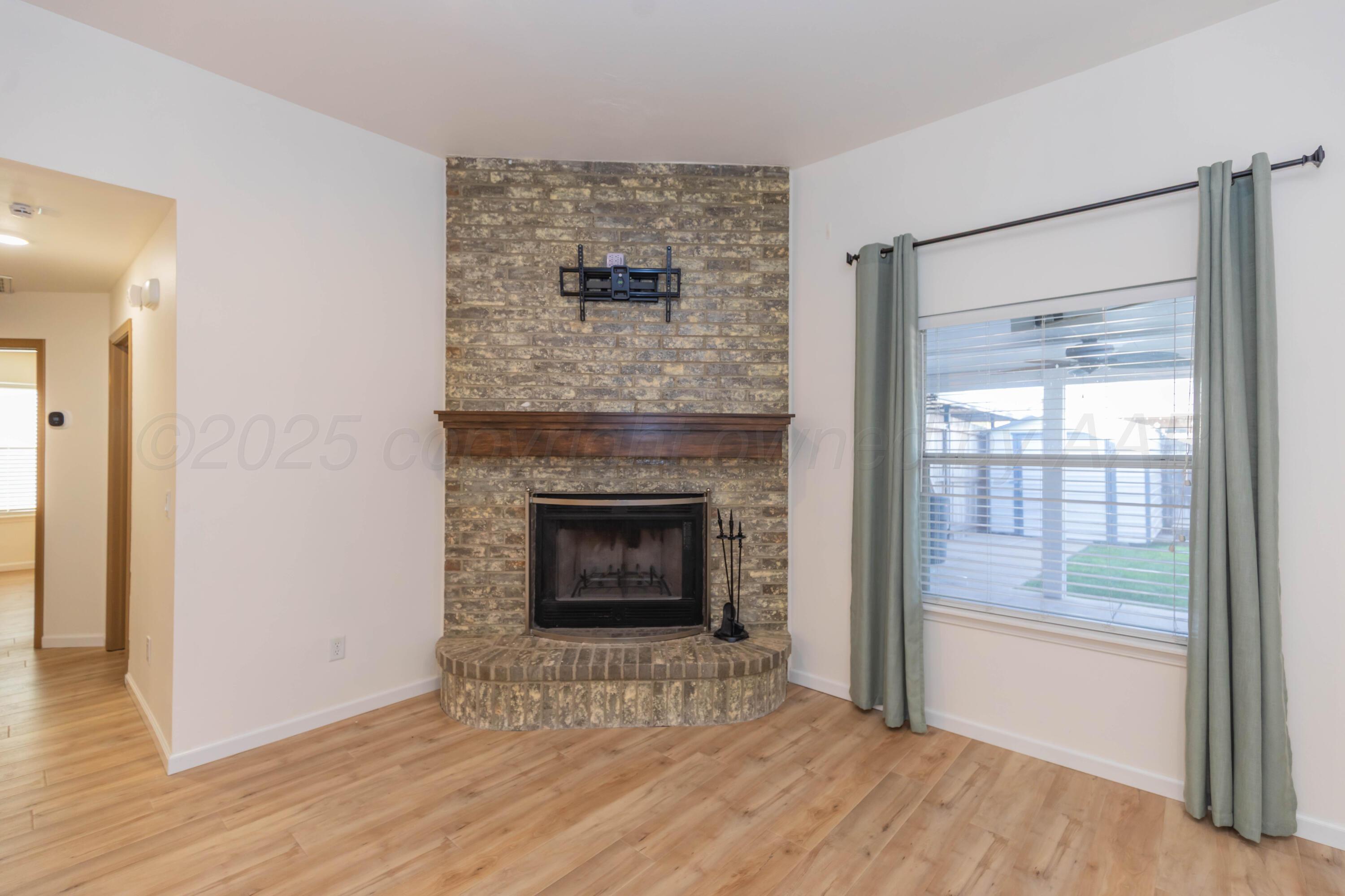 4810 Nimbus Lane Amarillo, TX 79110 - Photo 17 of 45 a view of an empty room with wooden floor fireplace and a window
