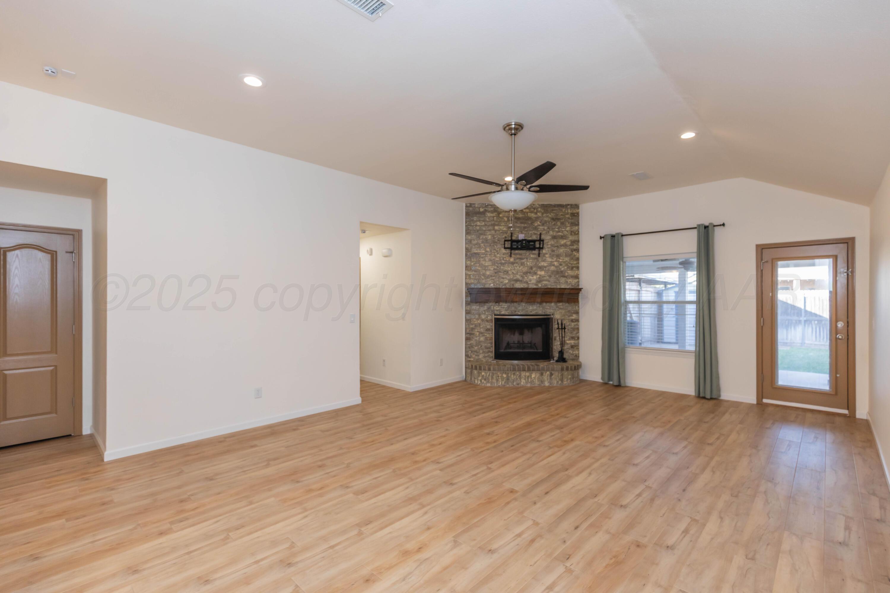 4810 Nimbus Lane Amarillo, TX 79110 - Photo 2 of 45 an empty room with wooden floor and fireplace
