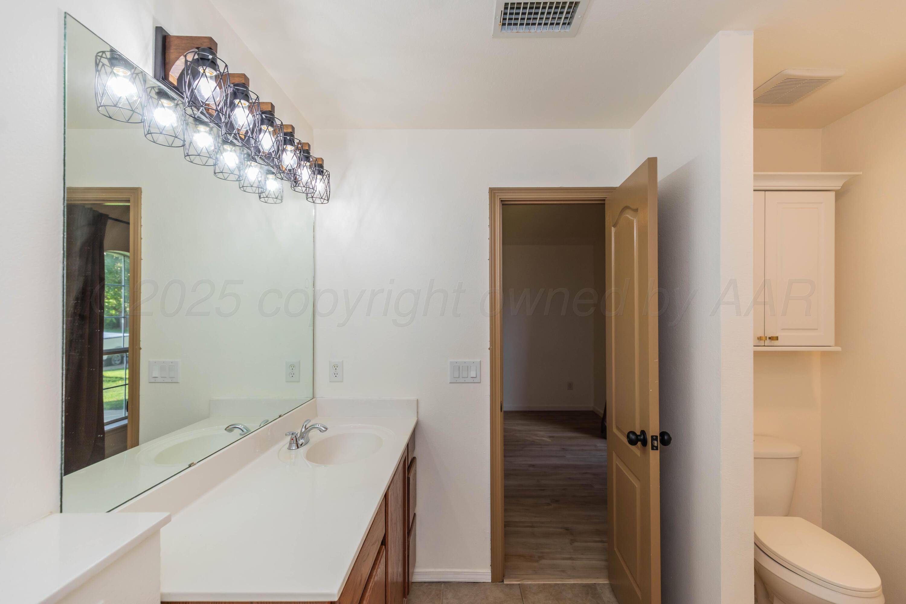 4810 Nimbus Lane Amarillo, TX 79110 - Photo 25 of 45 a bathroom with a sink a mirror and a shower