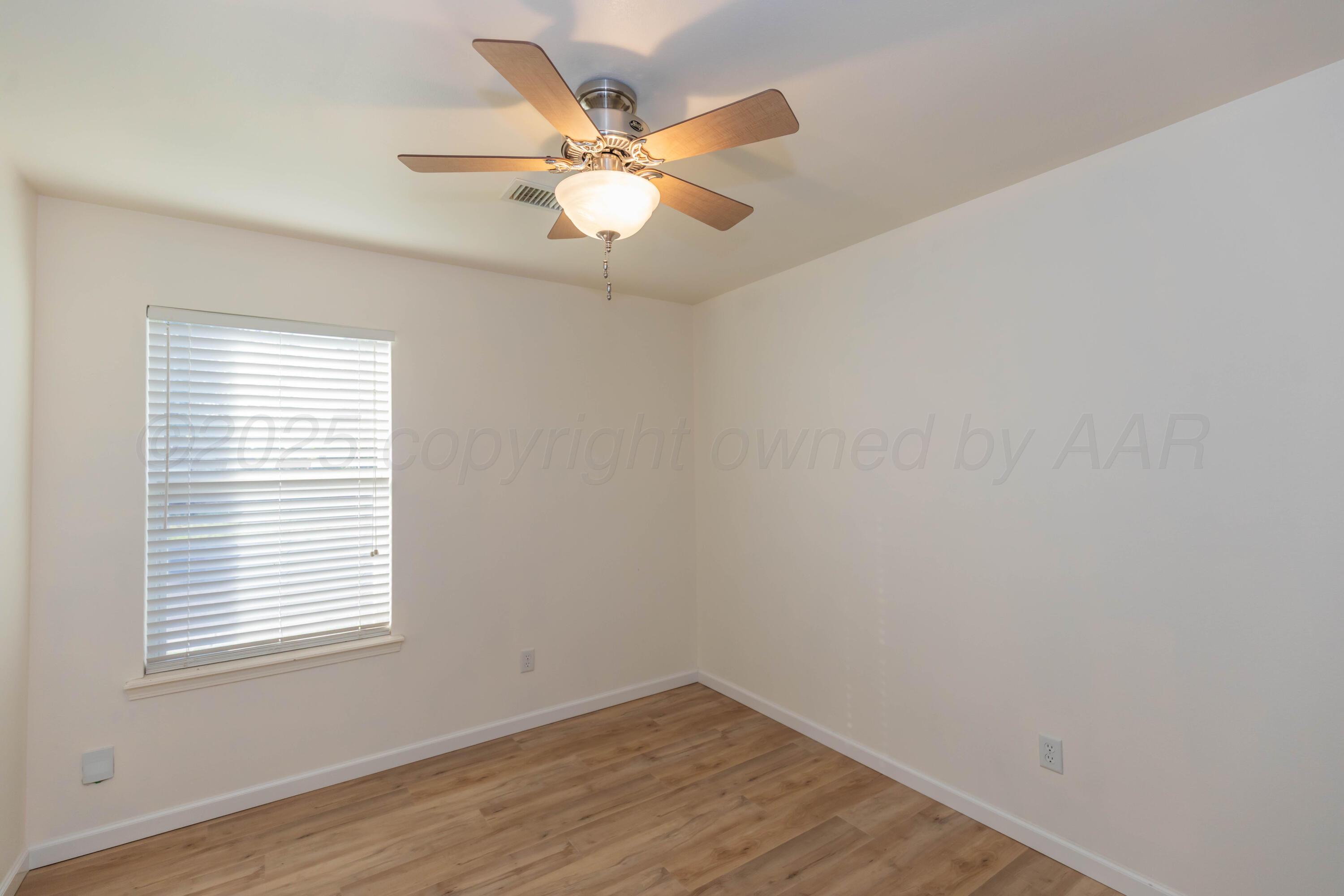 4810 Nimbus Lane Amarillo, TX 79110 - Photo 34 of 45 an empty room with wooden floor fan and windows