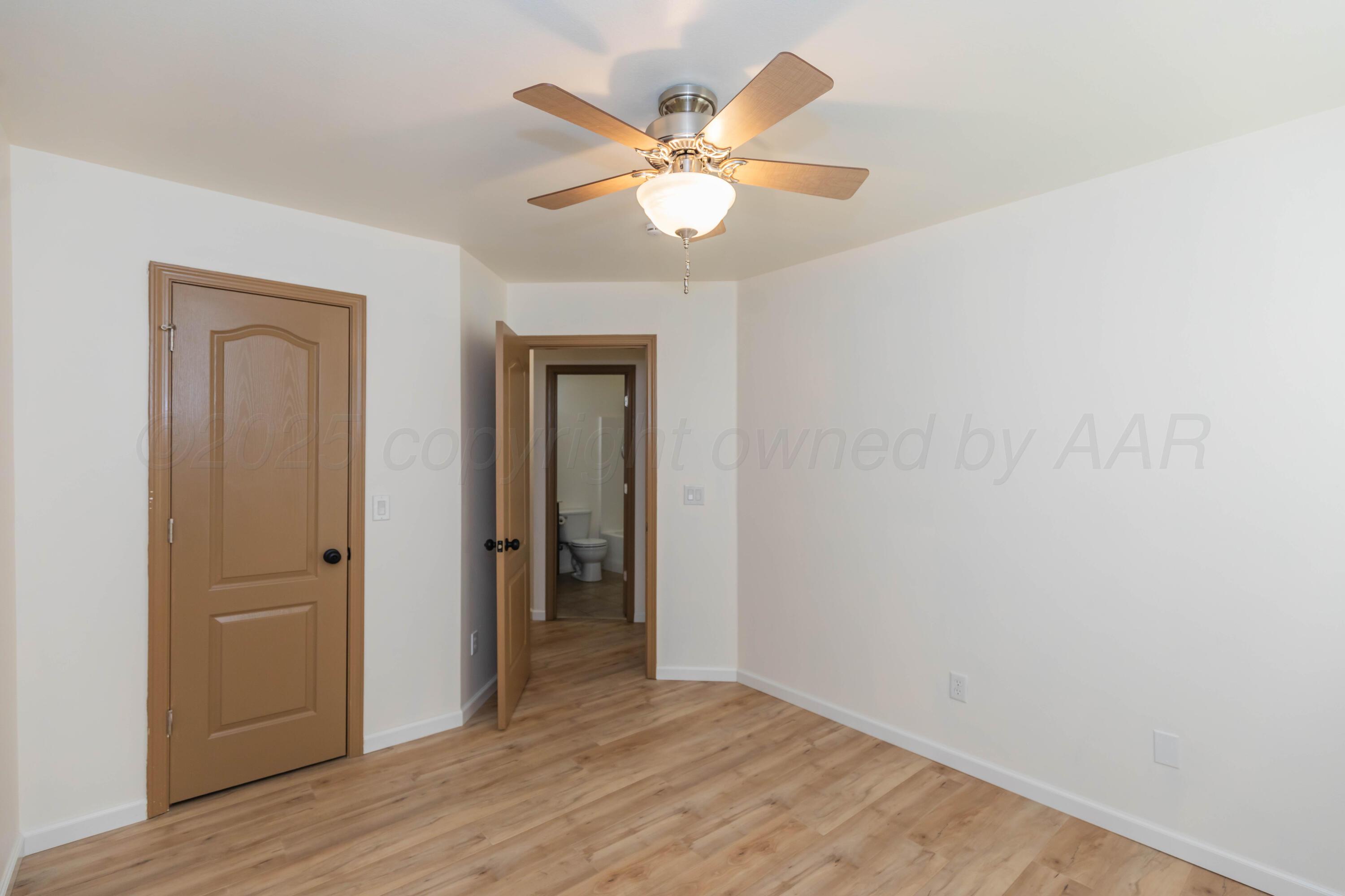 4810 Nimbus Lane Amarillo, TX 79110 - Photo 36 of 45 an empty room with wooden floor and ceiling fan