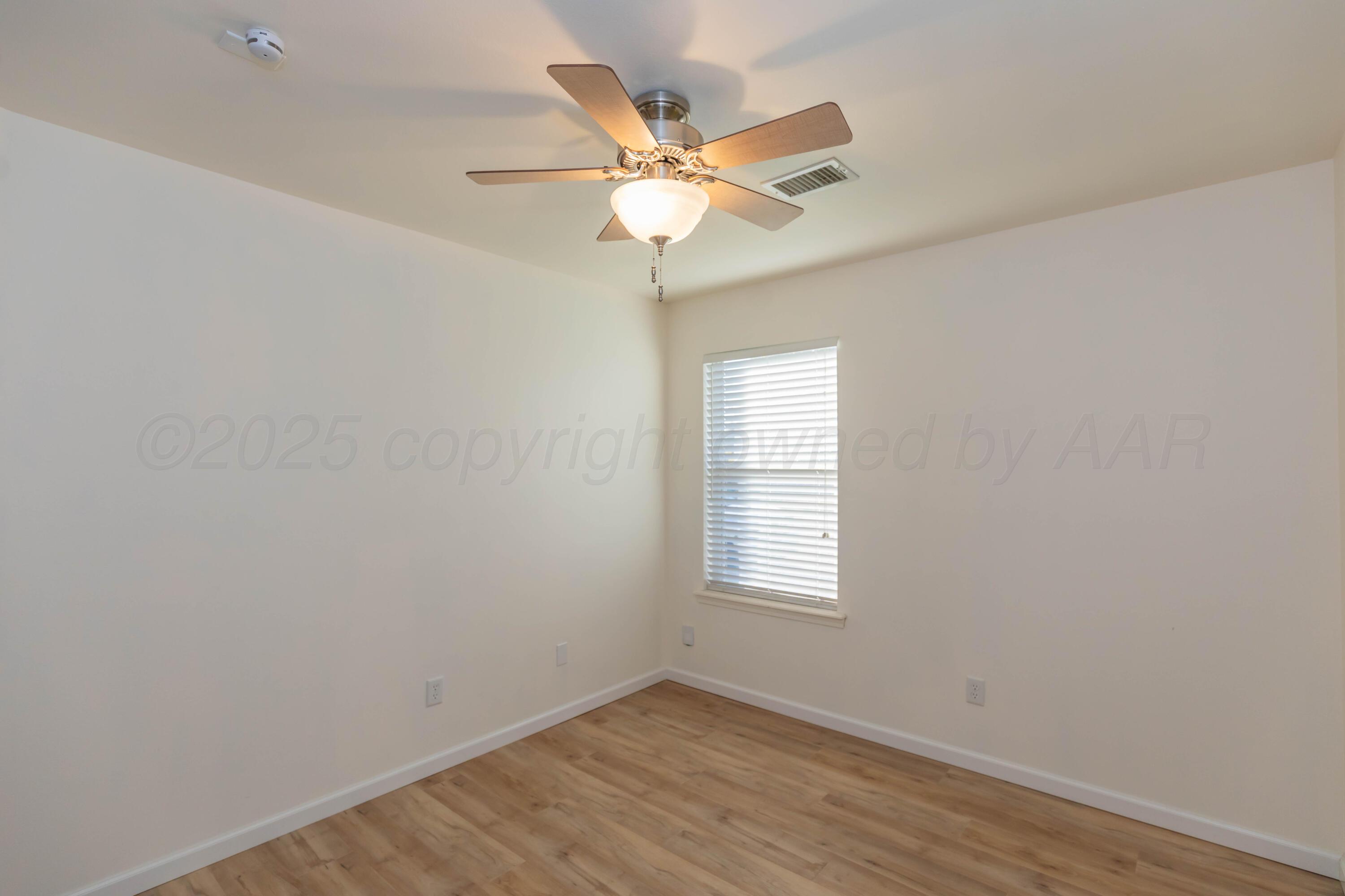4810 Nimbus Lane Amarillo, TX 79110 - Photo 37 of 45 an empty room with wooden floor fan and windows