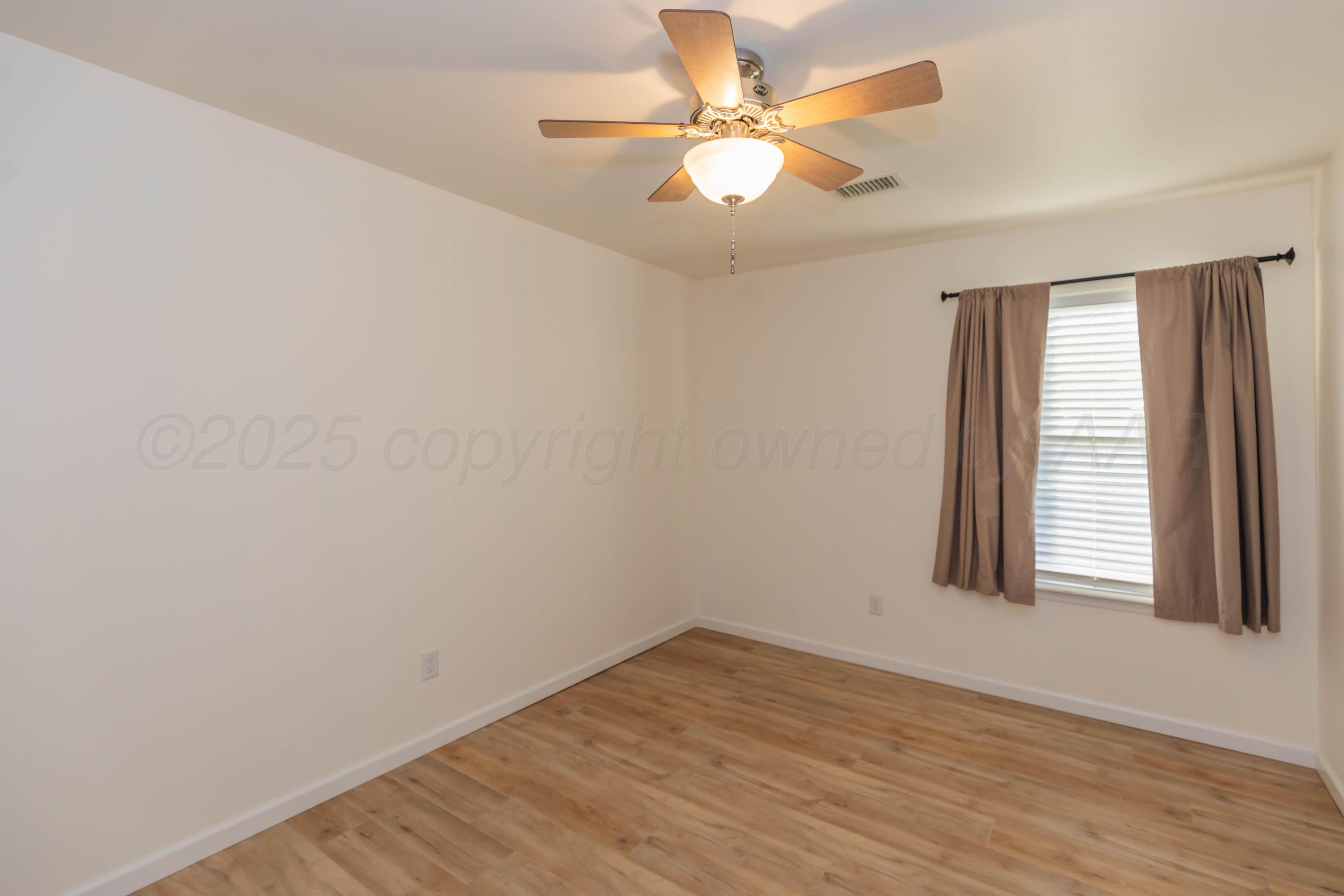 4810 Nimbus Lane Amarillo, TX 79110 - Photo 7 of 45 an empty room with wooden floor and windows