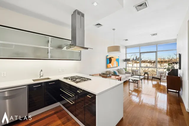 a kitchen with a sink a stove and chairs with wooden floor