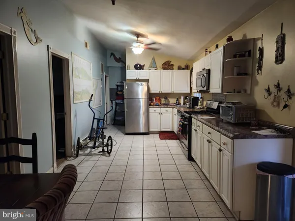a kitchen with a sink a refrigerator and cabinets