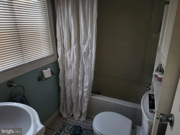 a white toilet sitting next to a bath tub