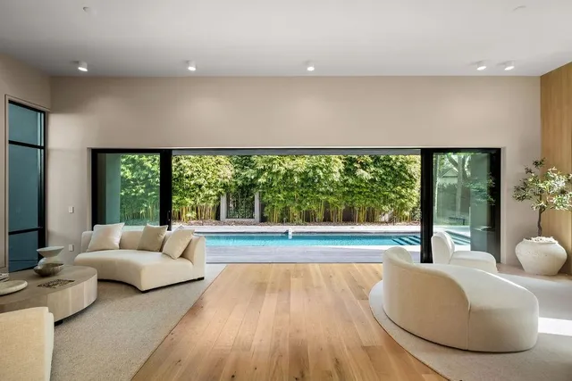 a view of a patio with couches and table and chairs with wooden floor and fence