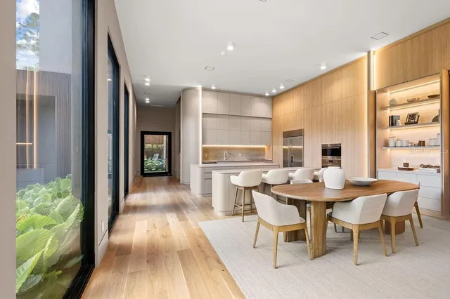 a large kitchen with stainless steel appliances a large counter top a stove and a large window