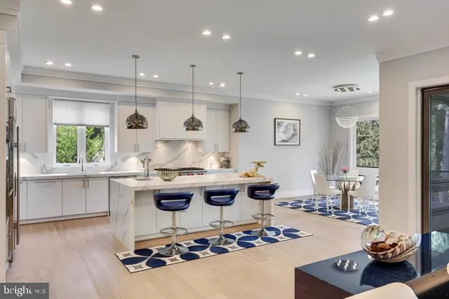 a kitchen with stainless steel appliances kitchen island granite countertop a stove a sink a oven a dining table and chairs