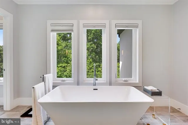 a kitchen with stainless steel appliances a dining table chairs refrigerator and cabinets