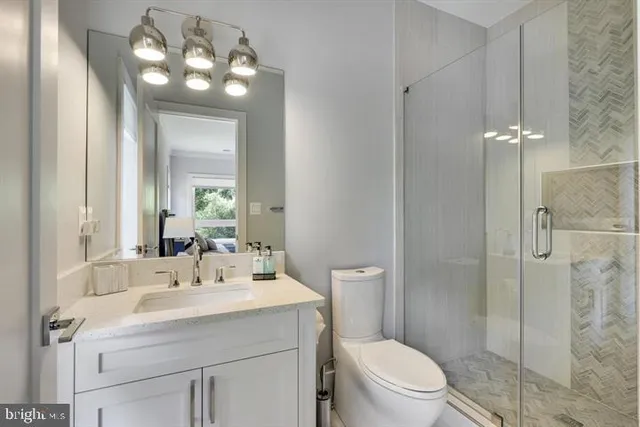 a bathroom with a sink a toilet and a large mirror