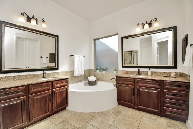 a spacious bathroom with a tub sink and mirror