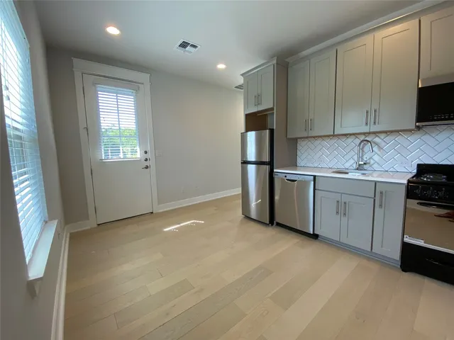 a kitchen with stainless steel appliances a refrigerator a sink a stove a microwave a sink and cabinets