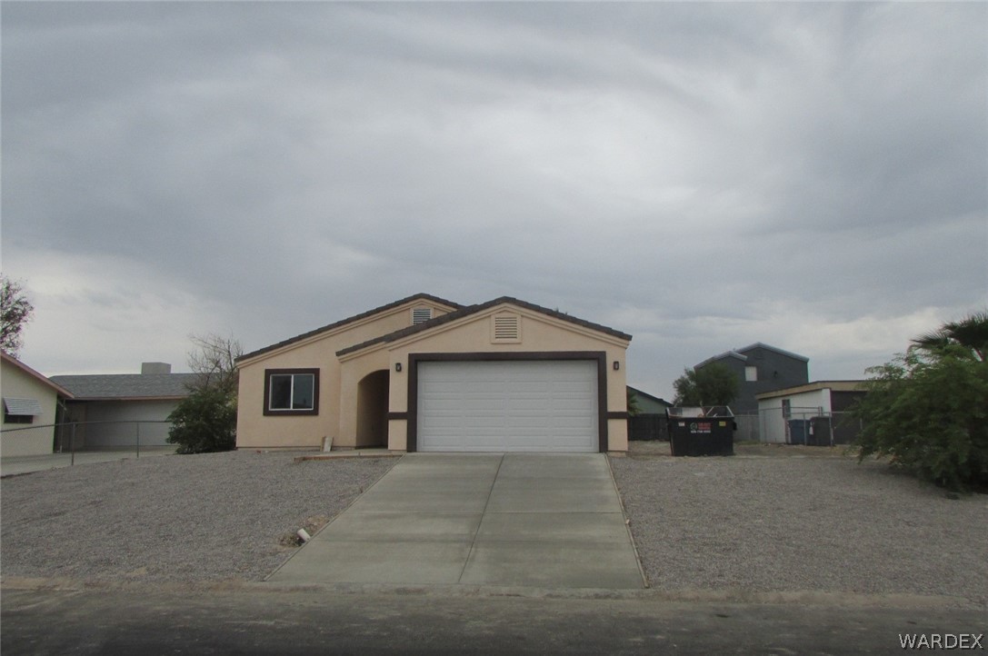 836 Ramar Road Bullhead City, AZ 86442 - Photo 1 of 10 a front view of a house with a yard and garage