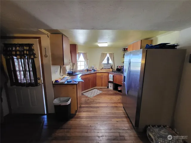 a dining hall with stainless steel appliances granite countertop a refrigerator and a sink