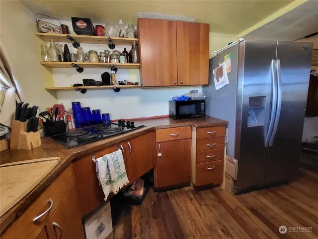a kitchen with stainless steel appliances granite countertop a refrigerator and wooden cabinets